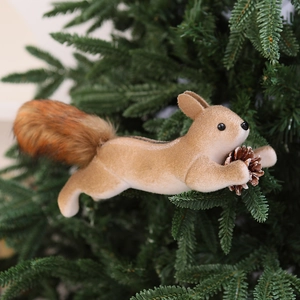 Close-up of decorative squirrel ornament with pinecone on green pine branch