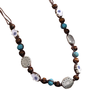 Detailed close-up of Bohemian braided waist chain with ethnic beads and Hamsa Hand charms