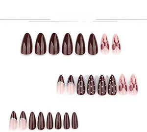Deep burgundy and pink almond press-on nails with delicate bow and dot patterns