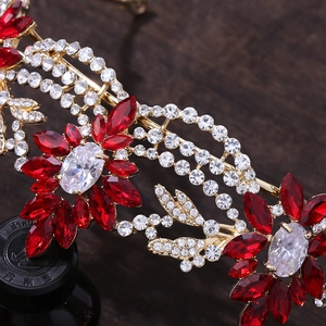 Macro view of crystal bridal crown with red rhinestones and gold floral alloy pattern