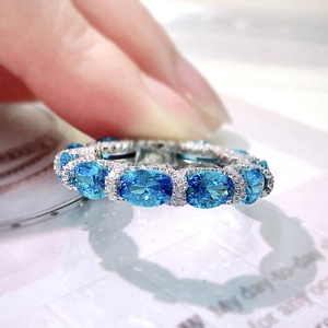 Macro shot of a 925 silver ring featuring sparkling blue gemstones and small diamonds