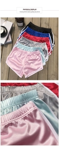 Detail of satin yoga shorts featuring white contrast binding and elastic waistband