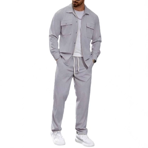 Ensemble décontracté deux pièces gris pour homme avec veste à poches et pantalon sur fond blanc