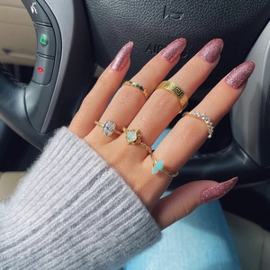 Six-piece gold plated ring set featuring opal and turquoise stones on a model's hand