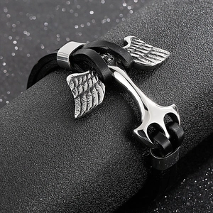Macro detail of men's leather anchor bracelet with silver stainless steel charm