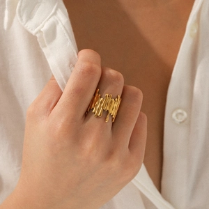 Detailed view of an 18K gold-plated irregular lava textured open ring on a woman's hand
