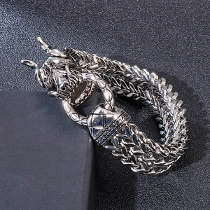 Macro detail of men's silver dragon bracelet with double-row wheat chain link design