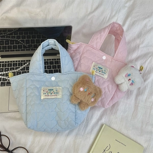 Close-up of quilted heart patterns on pastel blue and pink commuter tote bags
