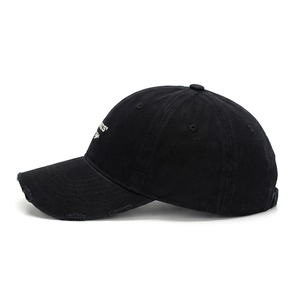 Dettaglio cappello baseball in cotone nero effetto consumato con ricamo bianco