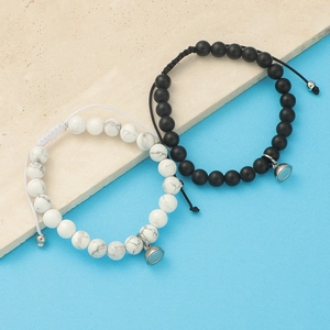 Detail of couple magnetic bracelets with white marble and matte black agate stones