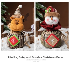 Detail view of handmade reindeer and snowman drawstring Christmas gift bags on snowy props