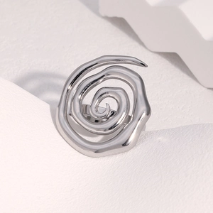 Dettaglio di un anello a spirale in argento su pietra bianca con ombre geometriche soft