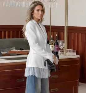 Detail of white blazer featuring blue lace patchwork hem and single-breasted buttons