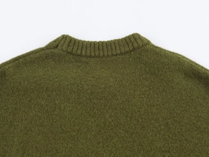 Detailed view of olive green knit sweater showing ribbed crew neck and soft wool texture
