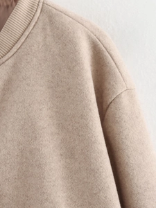Detailed close-up of oatmeal wool tweed jacket ribbed collar and shoulder stitching