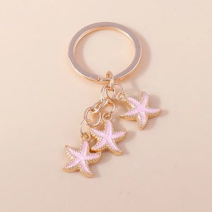Détails des pendentifs étoile de mer dorés avec émail rose sur un anneau porte-clés