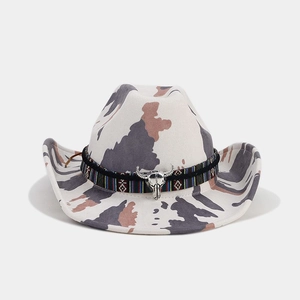 Detail of western cow print hat with ethnic woven band and silver bull skull charm