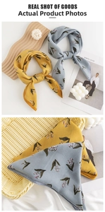 Detailed view of yellow and blue silk-like scarves with elegant lily of the valley prints