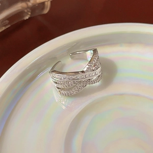 Detail of multi-layer crisscross open ring with zircon inlay on a ceramic display