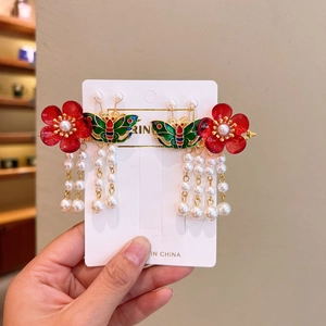 Detail of red flower hair clip with enamel butterfly and hanging white pearls