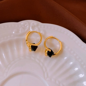 Gold-plated cube hoop earrings on vintage ceramic plate showing intricate geometric design