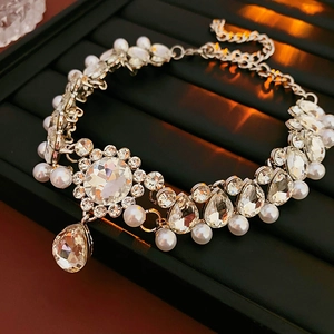 Detail of silver floral necklace with sparkling crystals and drop pearls on display