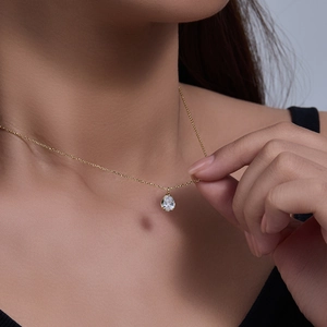 Detailed view of a gold waterdrop zircon pendant necklace worn on a woman's neck