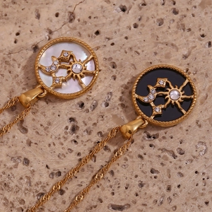 Detail of celestial round pendants with sun, moon, and stars on gold chain necklace