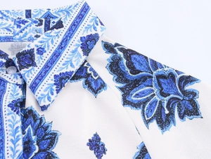 Detalle del cuello de solapa clásico y el estampado floral geométrico azul en un vestido camisero