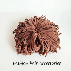 Close-up of thick brown elastic hair ties with knots on a clean white background