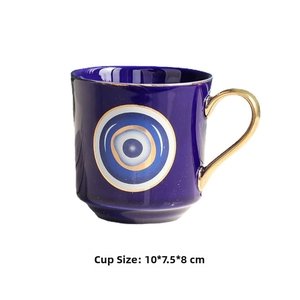 Detail of blue ceramic evil eye mug with gold handle and rim, size 10x7.5x8cm
