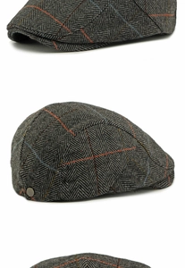 Close-up of grey herringbone flat cap fabric showing red and blue plaid detail