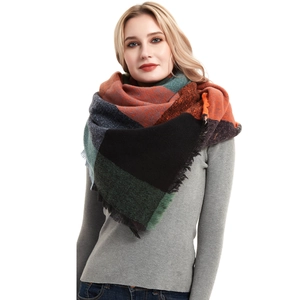 Detailed close-up of thick herringbone knit scarf with tassels and colorful plaid pattern