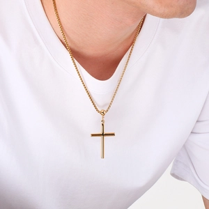 Minimalist gold stainless steel cross necklace with a polished box chain on a white t-shirt
