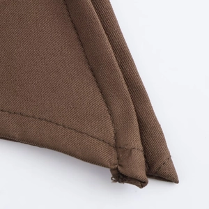 Macro shot of dark brown fabric texture and double-stitch sewing detail for sleeveless top