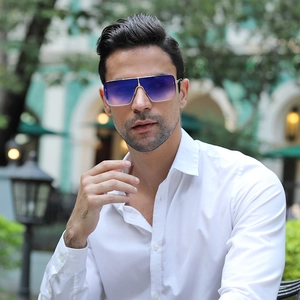 Detail of oversized gold metal sunglasses with purple gradient lenses worn by a model