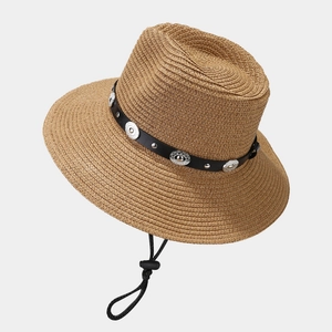 Detail of khaki straw hat featuring black leather band and silver metal studs with wind cord