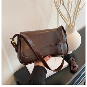 Detailed shot of brown vintage leather shoulder bag featuring elegant gold metal hardware