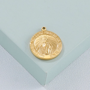 Detailed macro view of a gold stainless steel Virgin Mary pendant on a display stand