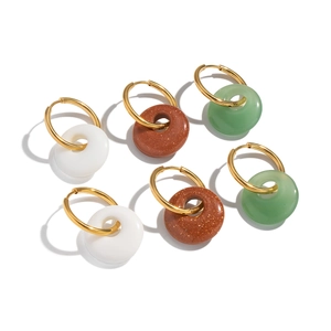 Three pairs of gold hoop earrings with natural stone donut pendants in white, brown, and green