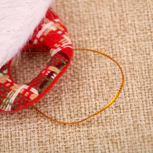 Detail of red plaid fabric and white faux fur on a Christmas pendant ornament