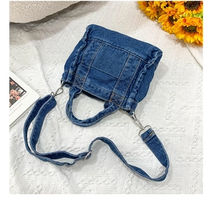 Detailed view of blue denim tote bag with stitching on white lace and sunflower decor