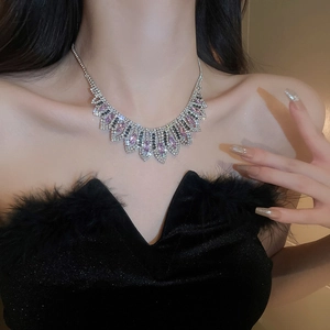 Close-up of silver geometric necklace with sparkling pink and clear crystals on a model