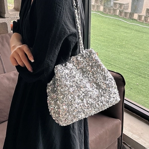 Silver sequin bucket bag with metal chain strap shown on a model for a stylish summer look