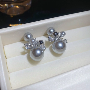 Détail de boucles d'oreilles en perles dorées 14 carats avec oxydes de zirconium