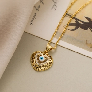 Detailed shot of gold heart pendant with evil eye bead and micro-pave crystals