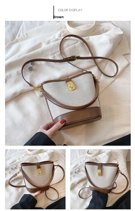 Detail of contrast bucket bag with gold twist-lock closure and adjustable strap