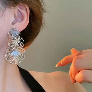 Vue détaillée de boucles d'oreilles rondes ajourées en argent sur un mannequin