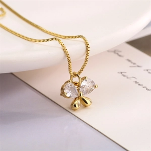 Close-up of golden butterfly pendant necklace with sparkling clear zircon inlay