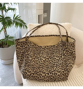 Close-up of leopard print tote bag with double straps on a cozy white armchair